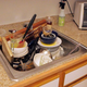 Illustration for article titled Master Architect Constructs Most Structurally Innovative Pile Of Dirty Dishes To Date